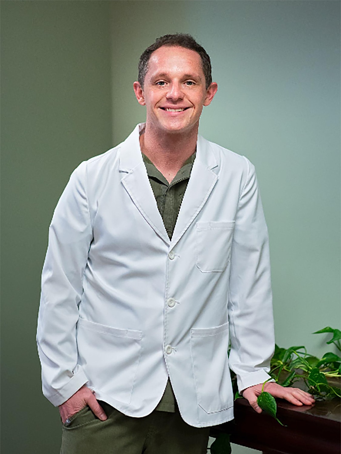 Smiling man in a white lab coat.